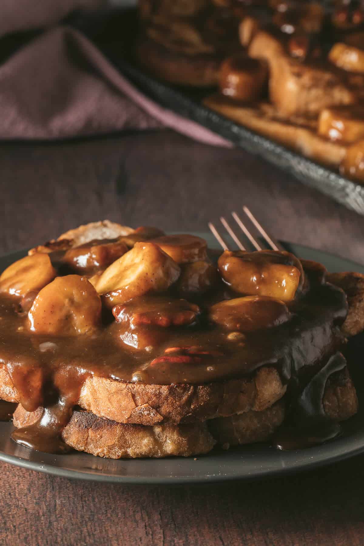 A serving of bananas foster french toast on a plate.