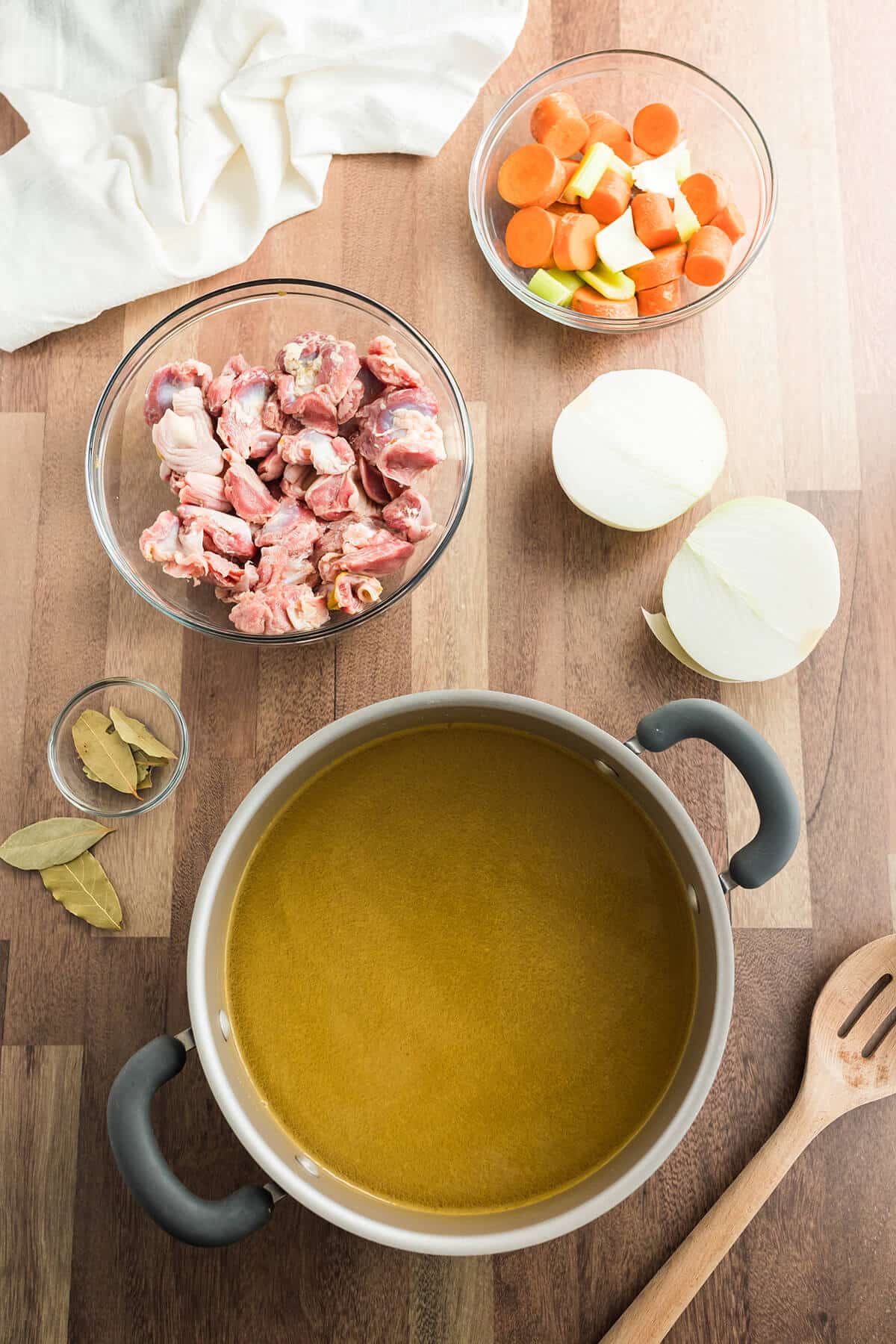A pot of stock with chopped giblets and vegetables.