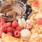 closeup of valentines day charcuterie board with raspberries and macarons.