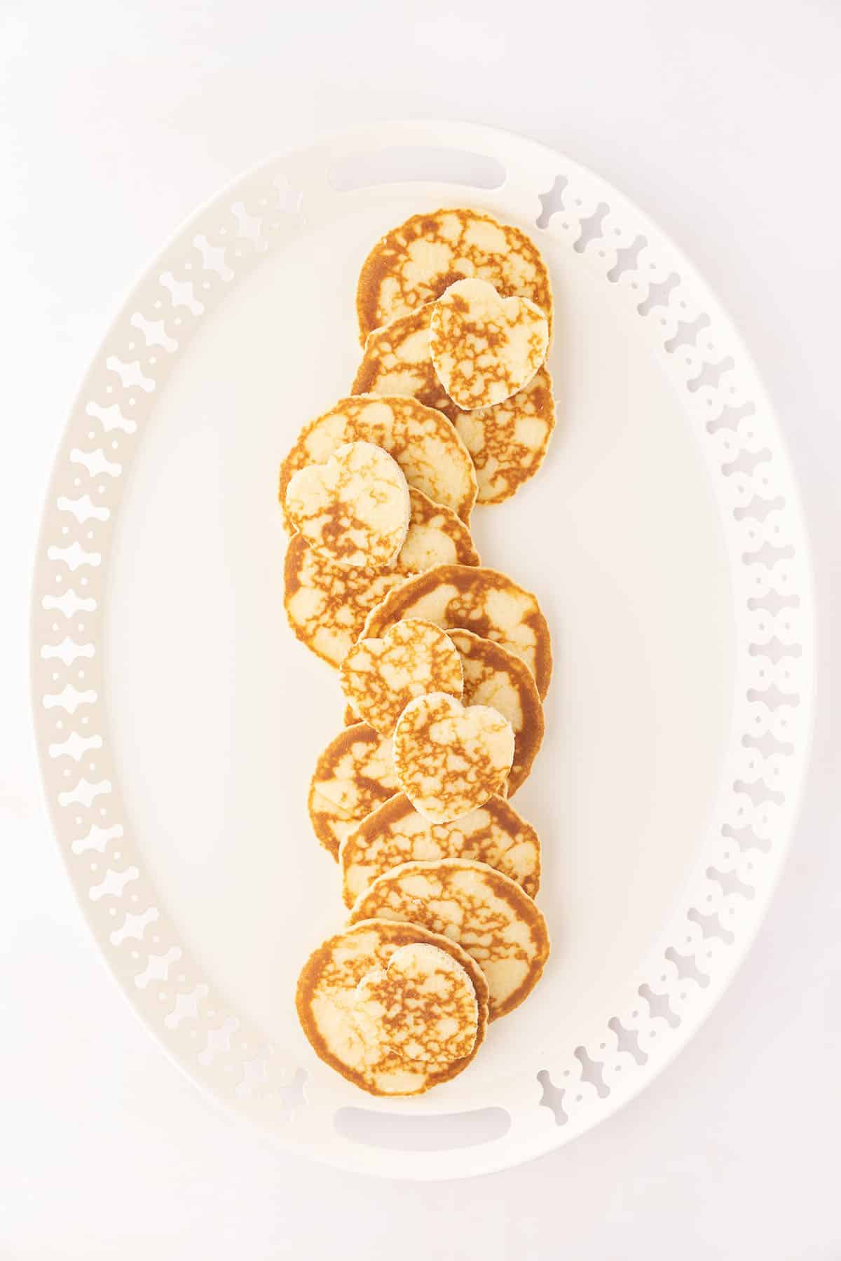 Mini pancakes on a white plate.