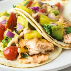 Salmon tacos filled with cooked salmon and fresh vegetables.