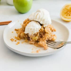 Baked apple crisp with no-oats topping on a white plate.