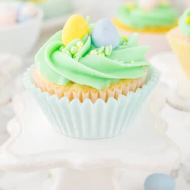 A side view of one Easter cupcake with green buttercream frosting.