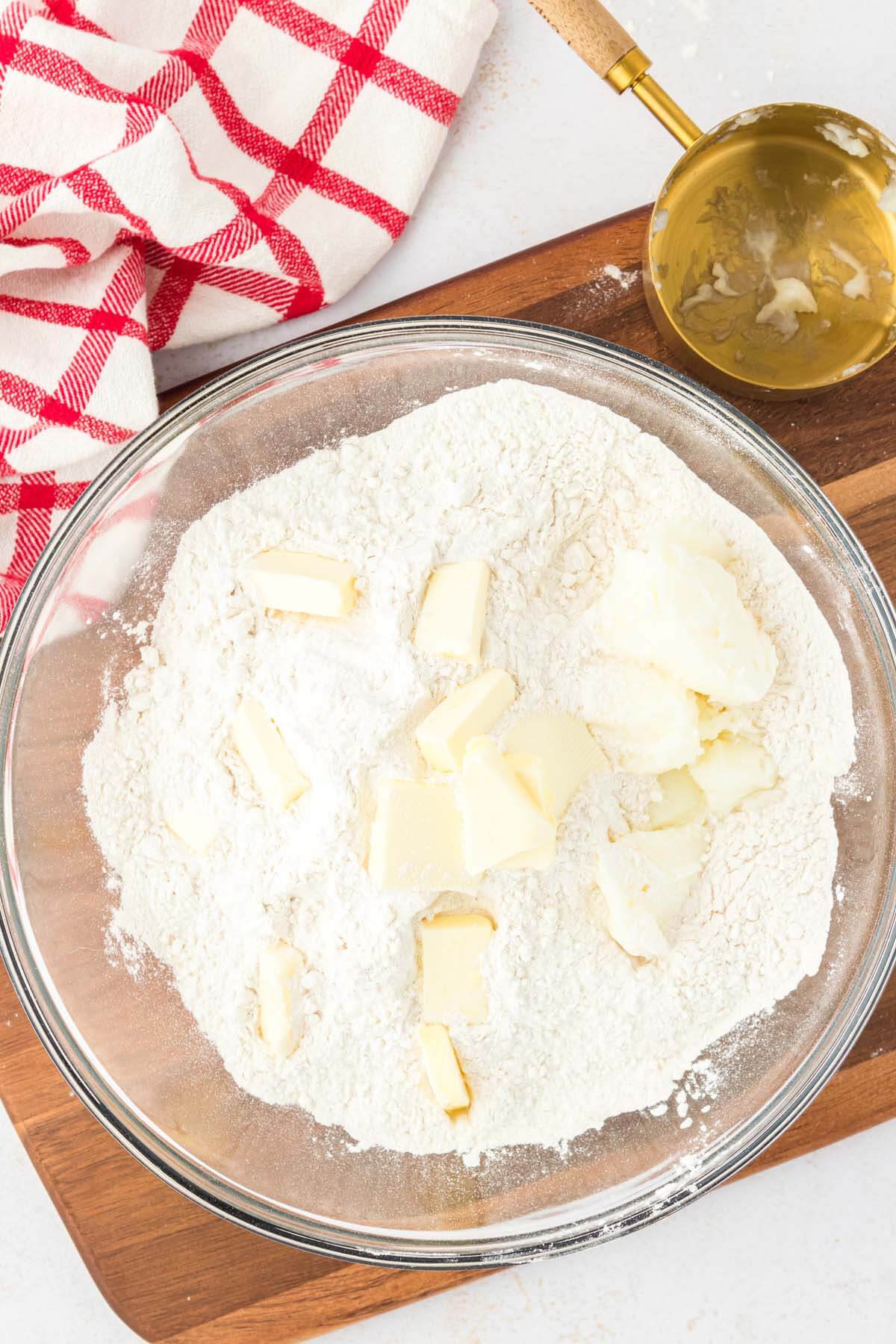 Butter chunks in a bowl of flour.