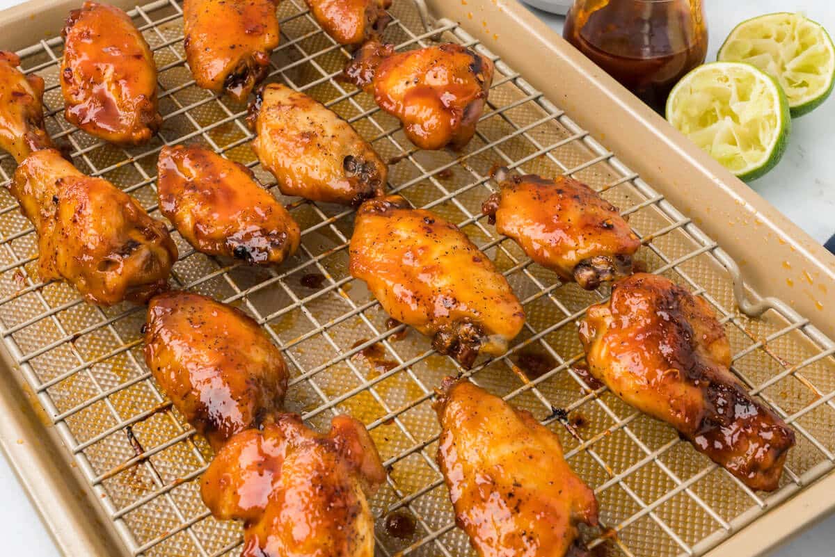 Baked chicken wings on a rack in a pan.
