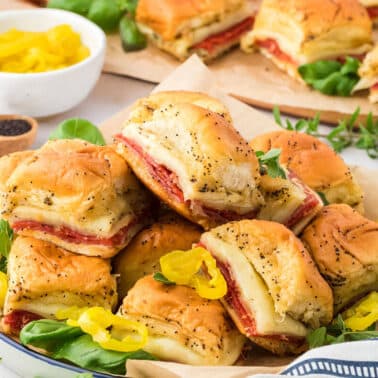 Italian sliders stacked on a white platter.