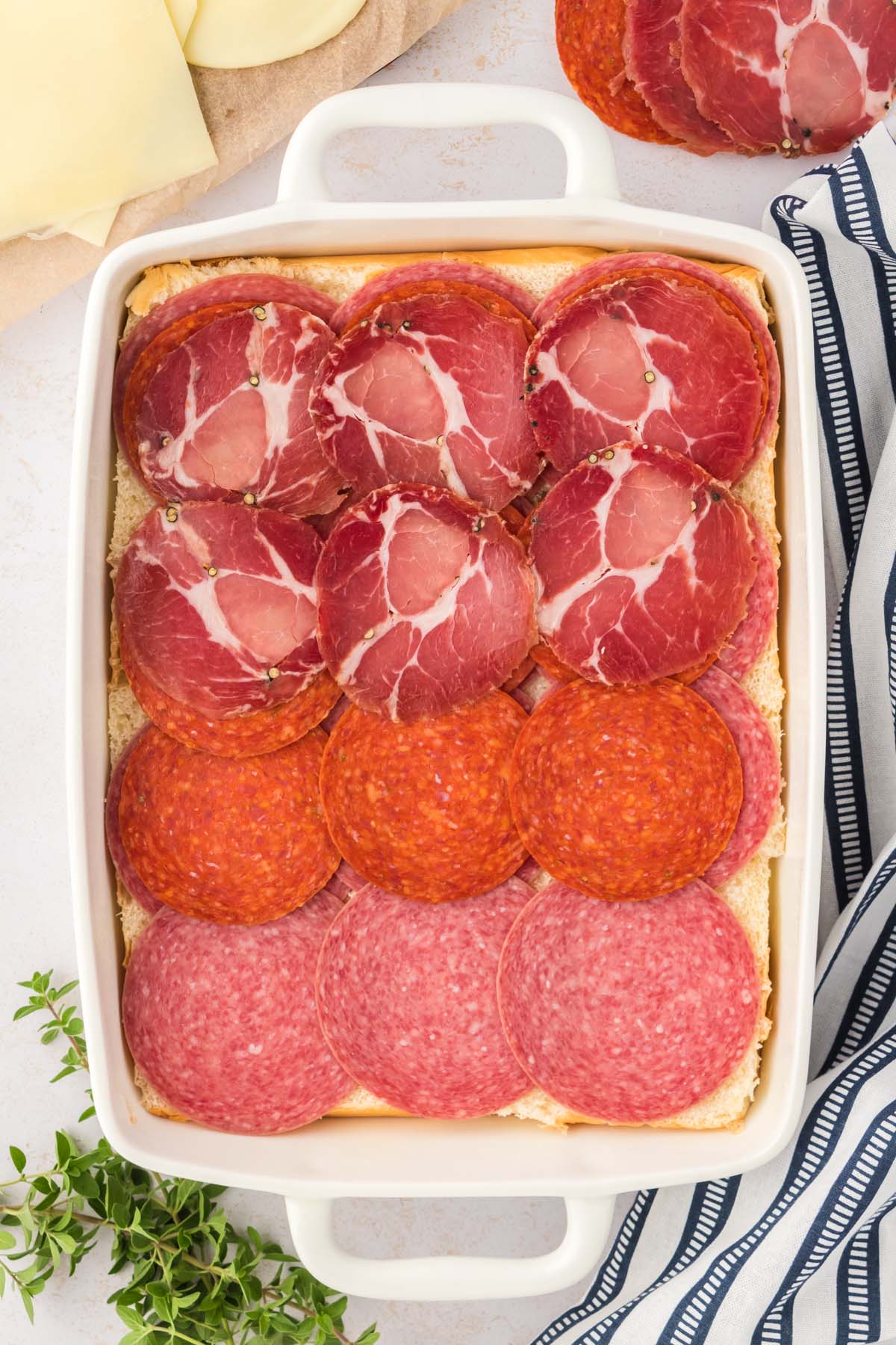 Meat slices placed over rolls in a dish.