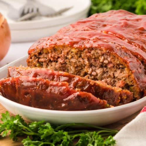 Sliced meatloaf on a white platter.