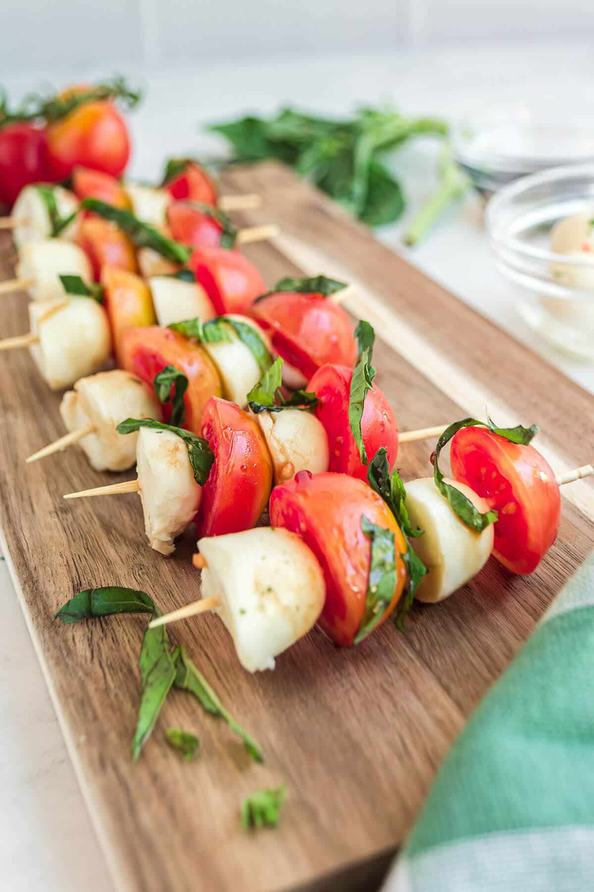 Side view of mini caprese skewers on a board.