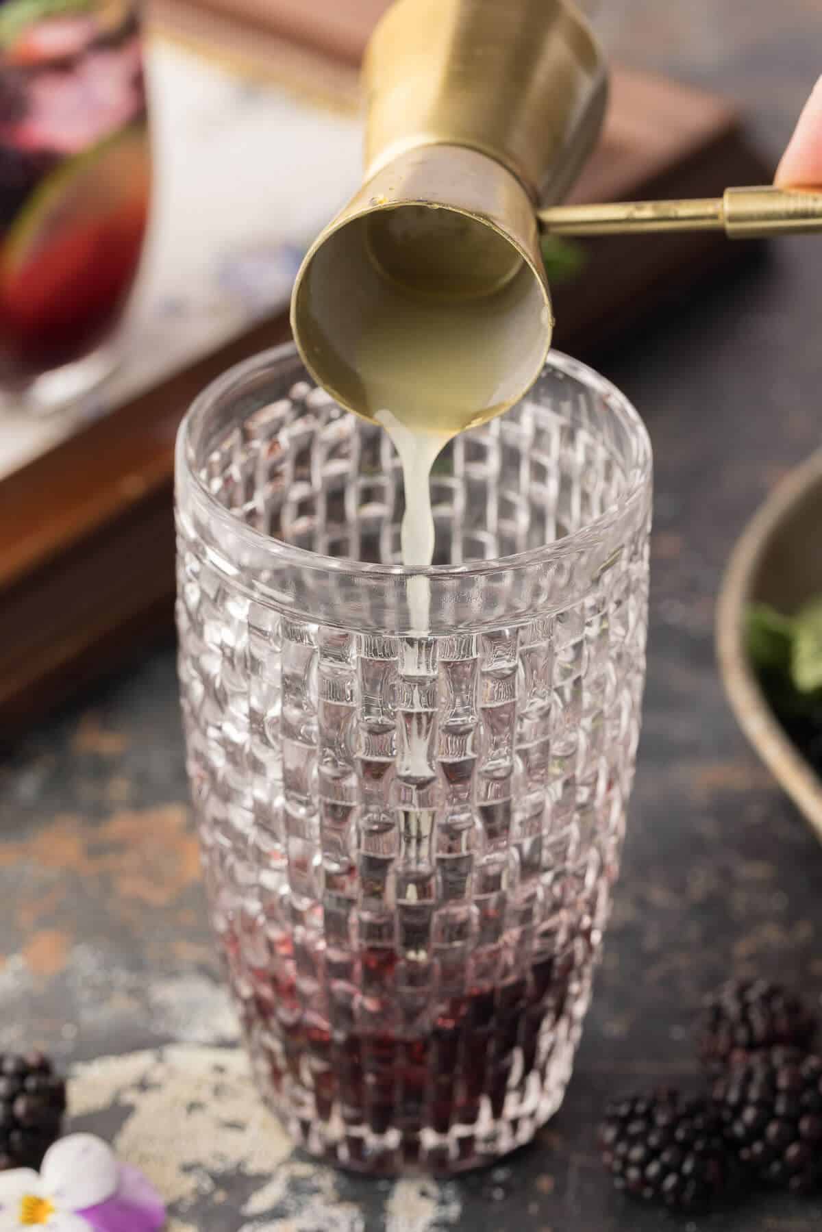 Pouring lime juice into a cocktail.