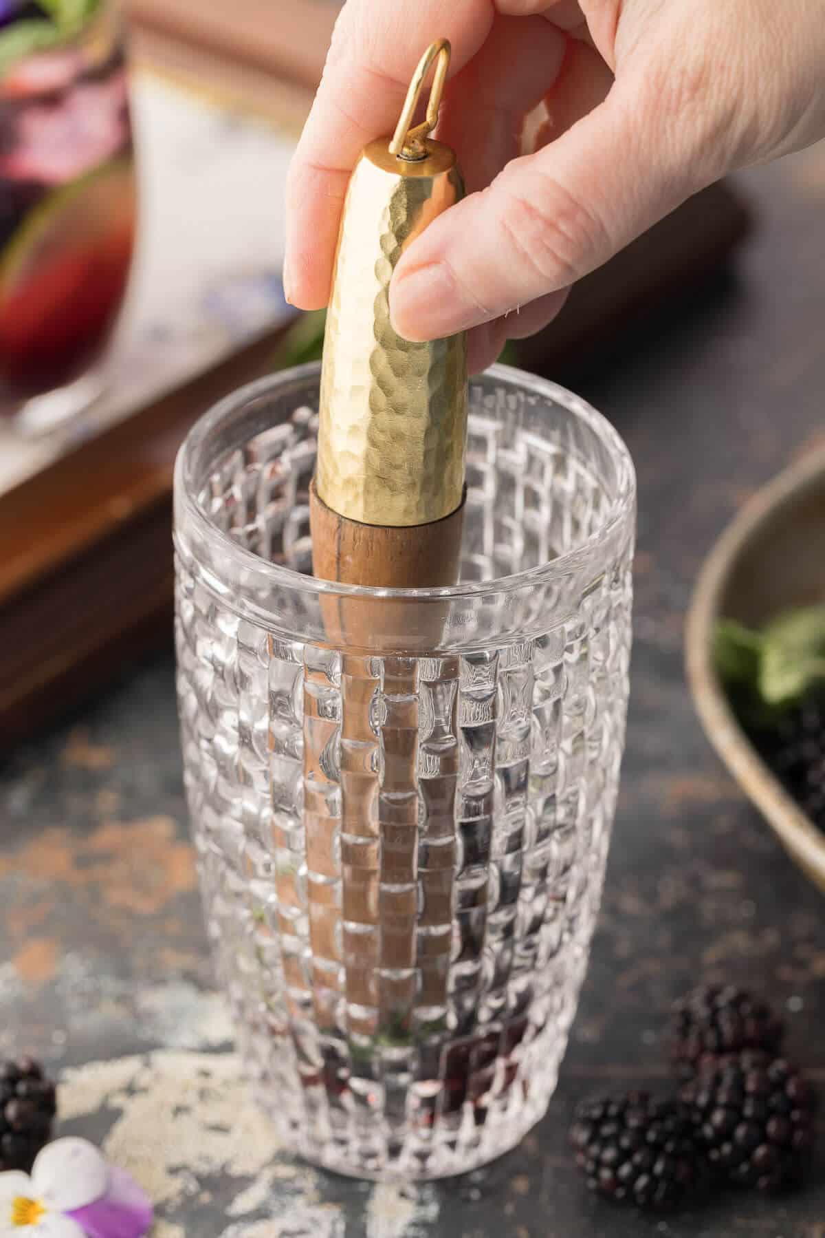 Muddling a cocktail in a glass beaker.