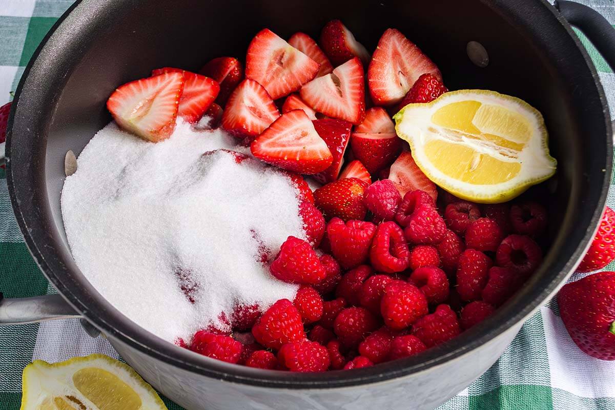 Berries in a pot with sugar.