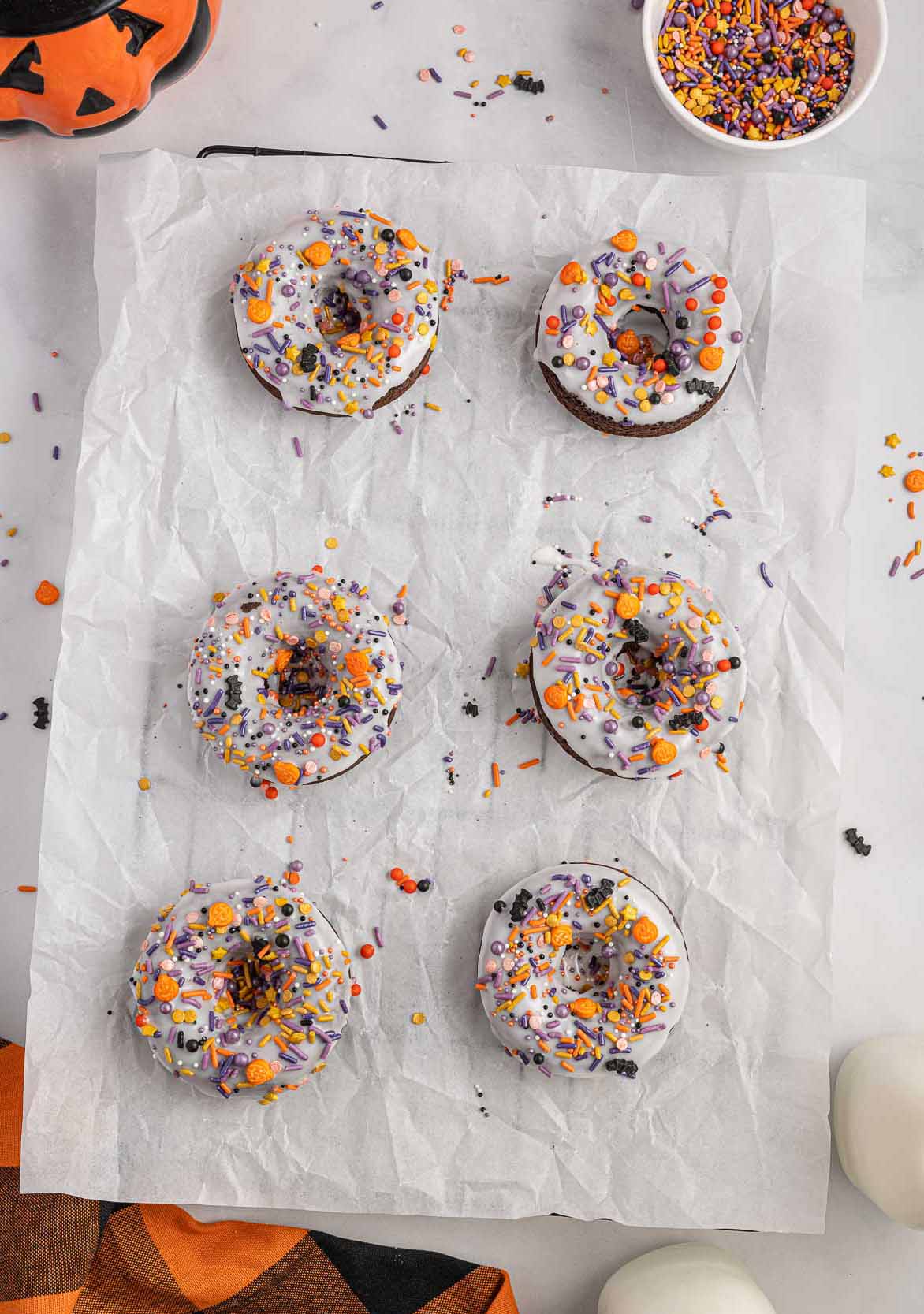 A parchment covered pan with Halloween donuts.