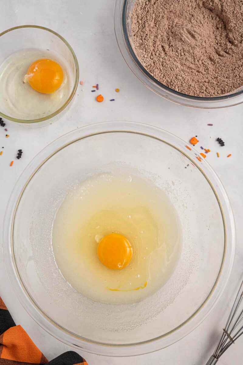 an egg mixed with oil in a glass bowl.