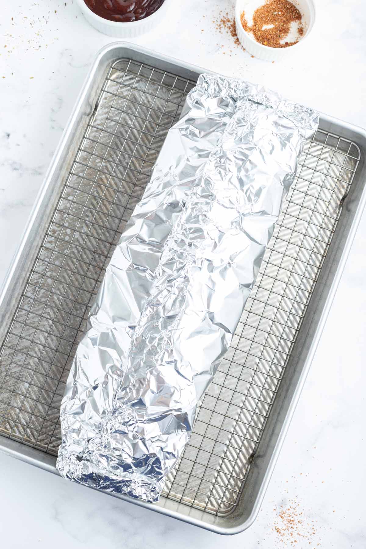 Ribs wrapped in aluminum foil.