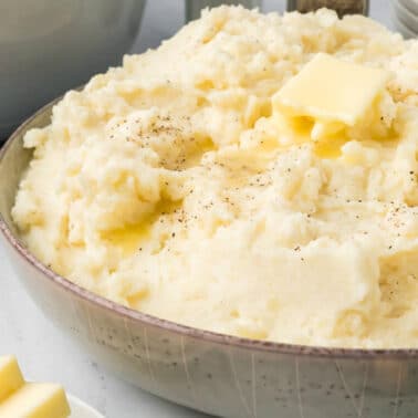 A bowl of Southern mashed potatoes with a pat of butter on top.