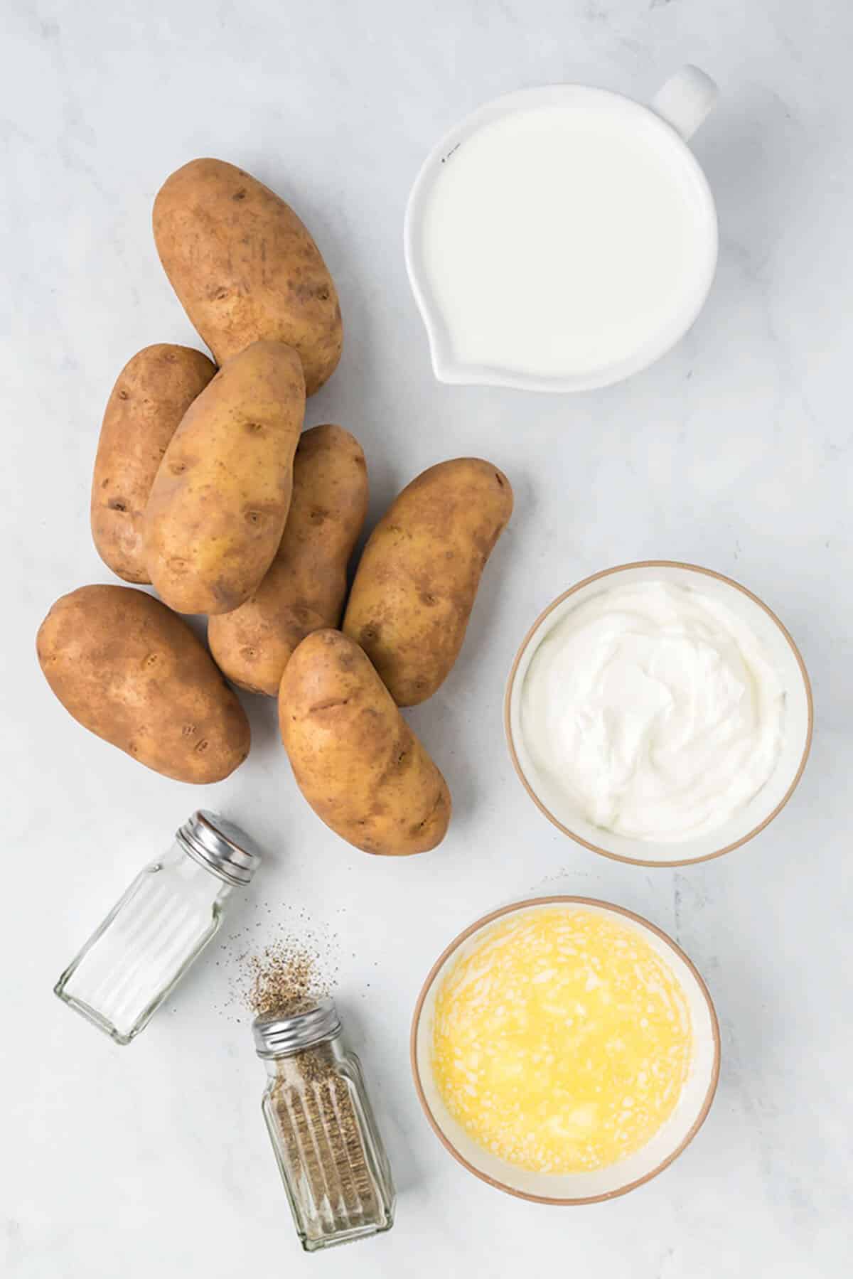 Sour cream, butter, and potatoes on the counter.