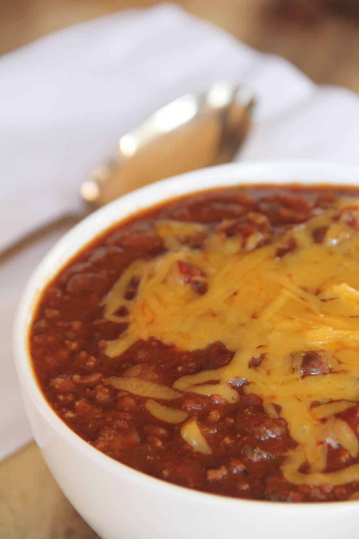 A bowl of chili with cheese.
