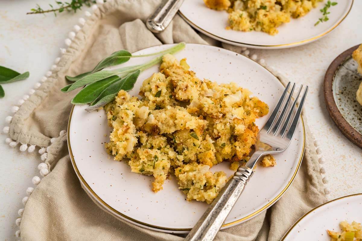 Cornbread dressing on a plate with a fork.