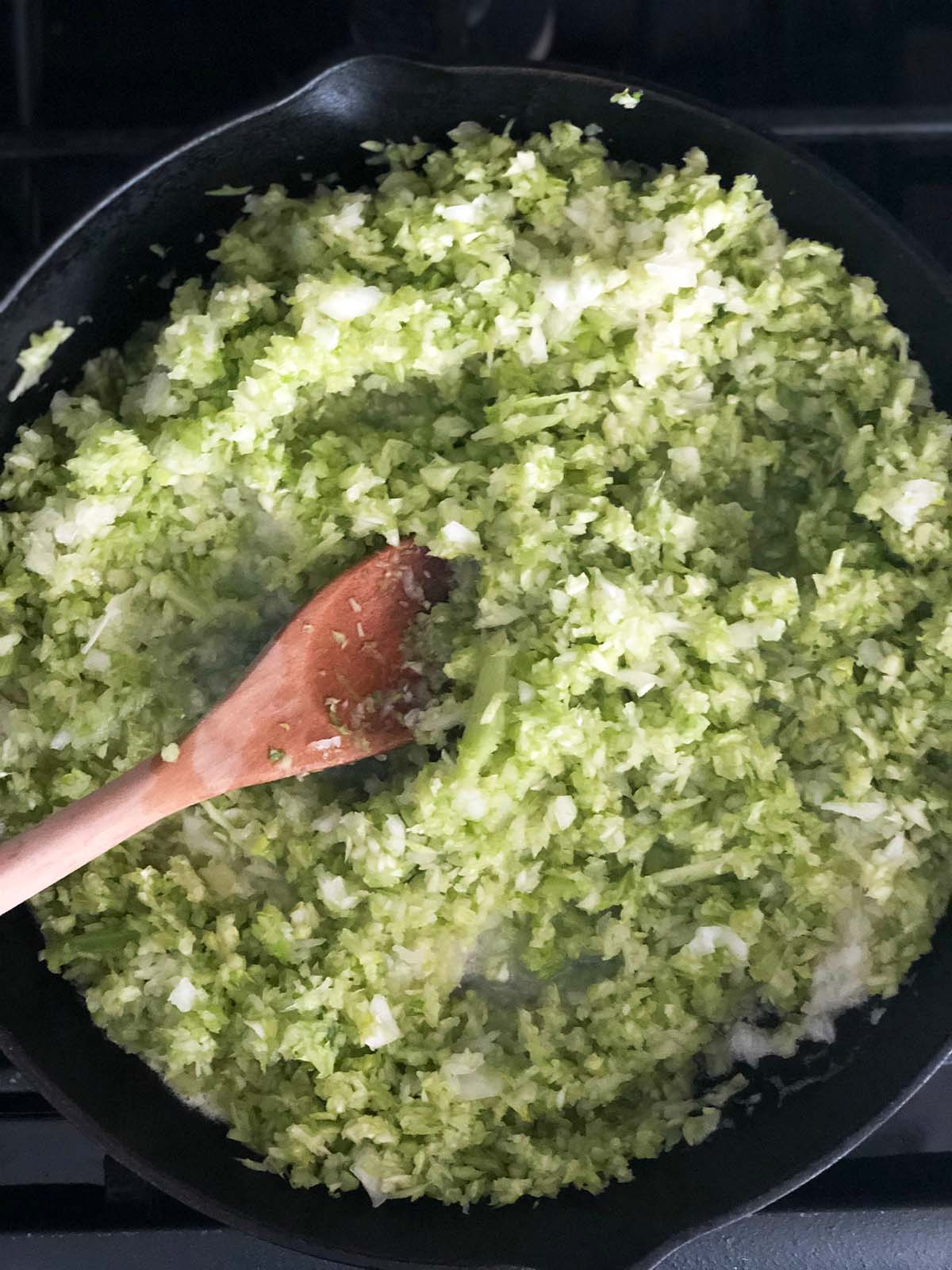 Stirring celery and onions in a skillet.
