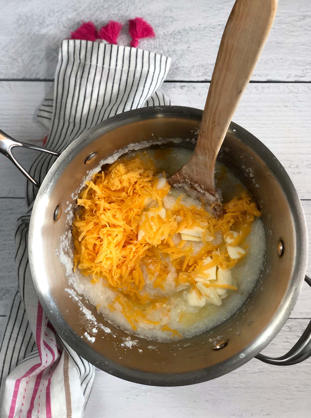 Stirring cheese into grits in a pot