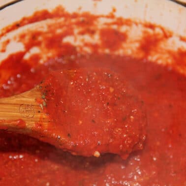 A spoon of sauce over a pot