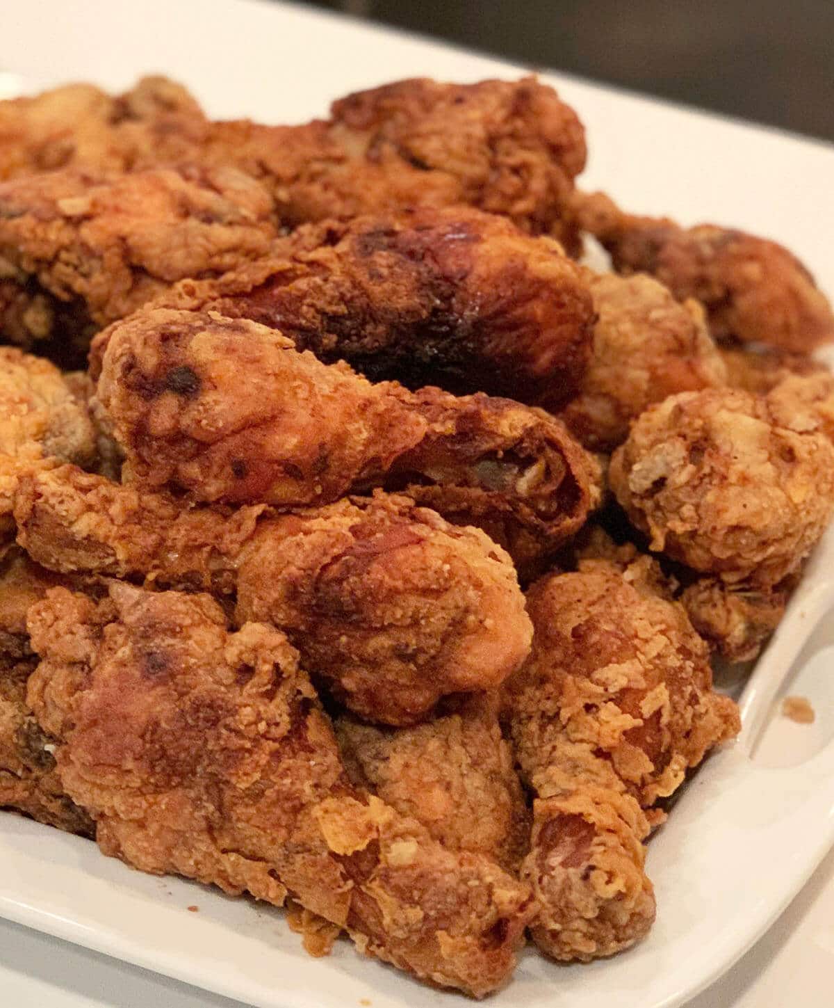 Southern style fried chicken on a white platter. 