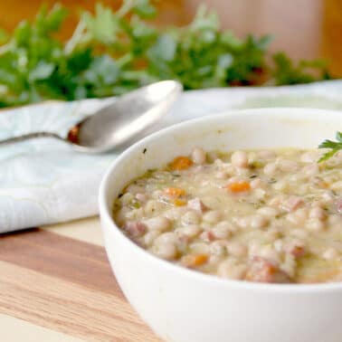 A white bowl of canned beans ham soup