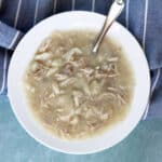 Chicken and dumplings in a white bowl.