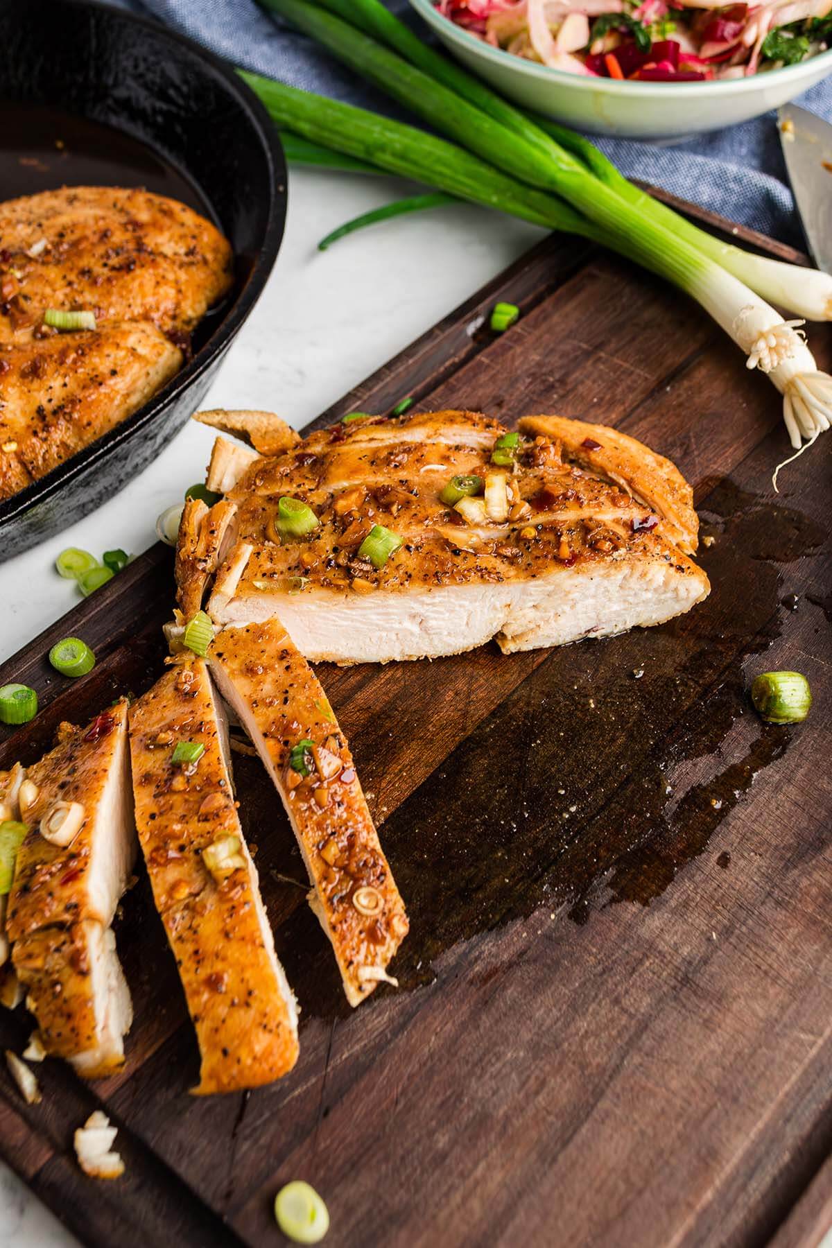 Slices of soy garlic chicken on a board.