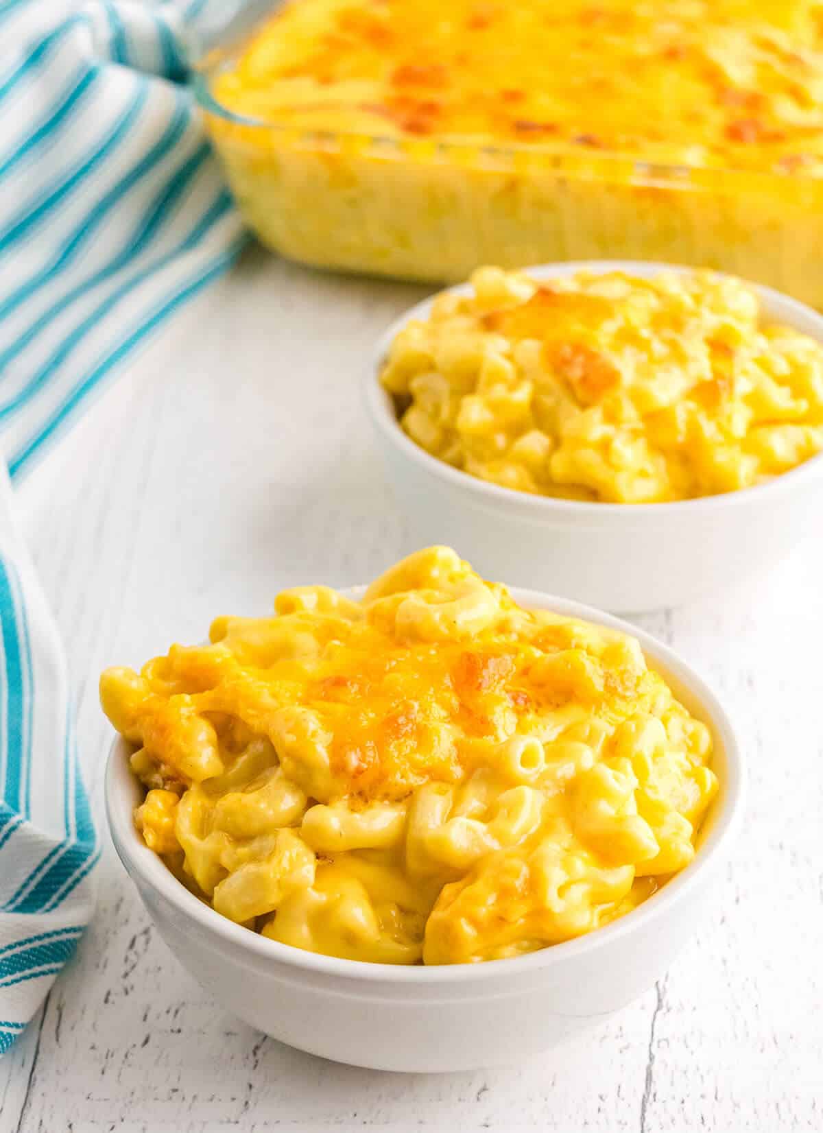 A white serving bowl filled with creamy baked mac and cheese.