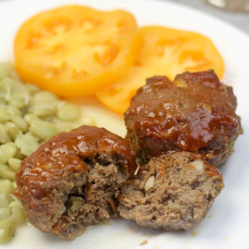 A plate with vegetables and meatloaf muffins.