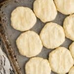 A baking sheet with unbaked, evenly spaced biscuits arranged in rows.