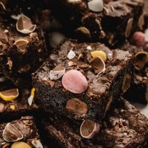 Close-up of several chocolate brownies topped with colorful candy-coated chocolate pieces.