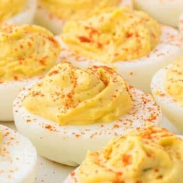 A close-up of deviled eggs topped with a sprinkle of paprika.