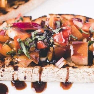 Grilled bread topped with diced tomatoes, herbs, and drizzled balsamic glaze.