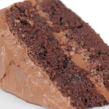 A slice of Hershey's chocolate cake with two layers and chocolate frosting on a white plate.