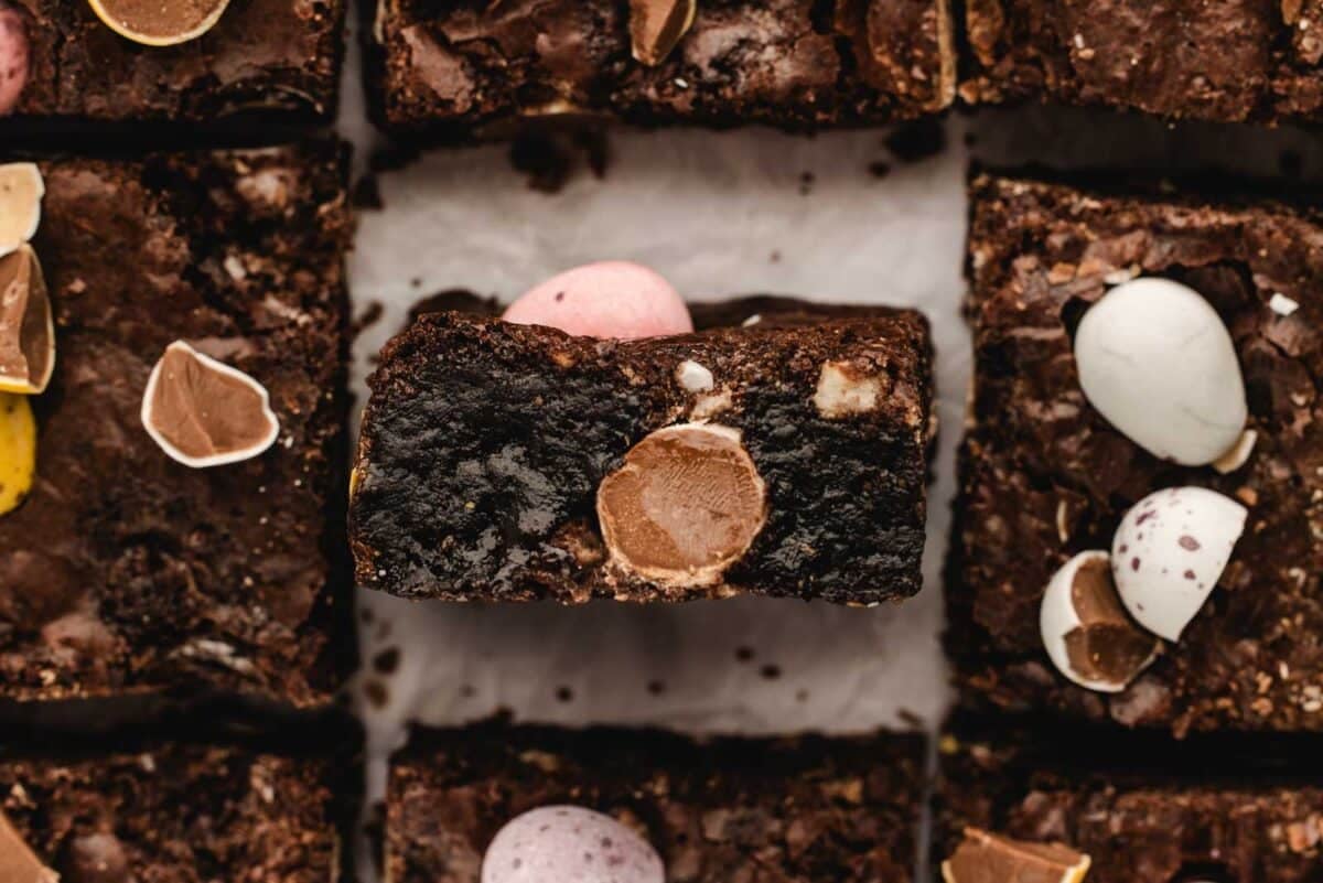 Easter Brownies topped with chocolate eggs, one placed in the center, surrounded by others.