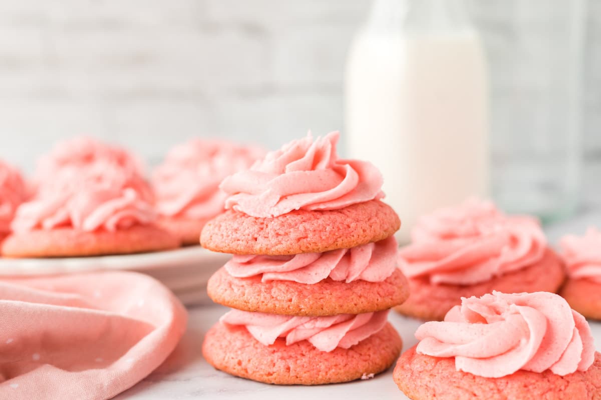 Soft-centered sugar cookies with crisp edges and a strawberry Jell-O buttercream frosting 