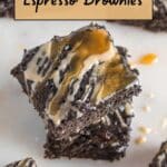 A stack of espresso brownies topped with a light brown and caramel drizzle on a white surface.