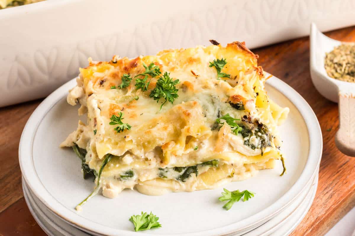 Cheesy chicken Alfredo lasagna layered with tender noodles, creamy spinach sauce,