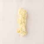 A mound of herbed butter is placed on a sheet of white parchment paper.