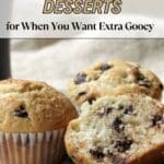 Two chocolate chip muffins, one with a bite taken out, sit on a plate with scattered chocolate chips. Text reads: "12 Chocolate Chip Desserts for When You Want Extra Gooey.