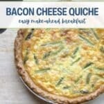 A baked bacon cheese quiche with asparagus sits on a light surface next to a serrated knife. Text reads "Bacon Cheese Quiche: easy make-ahead breakfast.