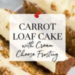 Sliced carrot loaf cake topped with cream cheese frosting and walnut pieces, displayed on a white plate with a bowl of walnuts in the background.