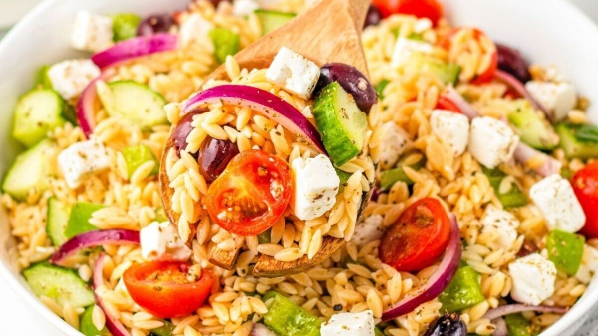 A bowl of orzo pasta salad with cherry tomatoes, cucumber, red onion, kalamata olives, feta cheese, and green bell pepper tossed with herbs—one of those easy recipes perfect for messy kitchens.