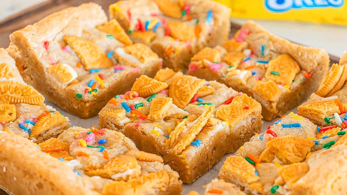 Golden Oreo cookie bars are the ultimate easy blondies—topped with crumbled Golden Oreos and colorful sprinkles, then cut into squares and arranged on a baking sheet. Perfect for anyone who loves blondie recipes or creative dessert recipes.
