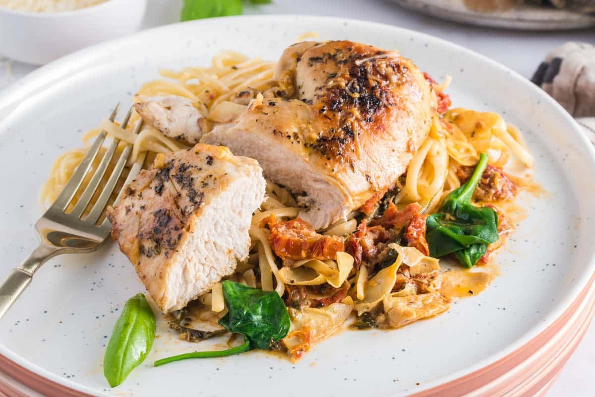 Creamy Tuscan Chicken with sun-dried tomatoes, spinach, artichokes, and Parmesan in a rich garlic