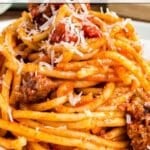 Close-up of pasta topped with tomato sauce, meat, and grated cheese; text overlay reads "14 Sauce Recipes That Bring the Flavor.