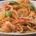 Plate of spaghetti topped with sliced tomatoes, fresh basil, and cheese, with the text "19 Fresh Tomato Dishes" at the top and "southernfoodandfun.com" at the bottom.